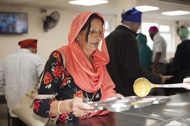 Woman being served food at a Sikh kitchen