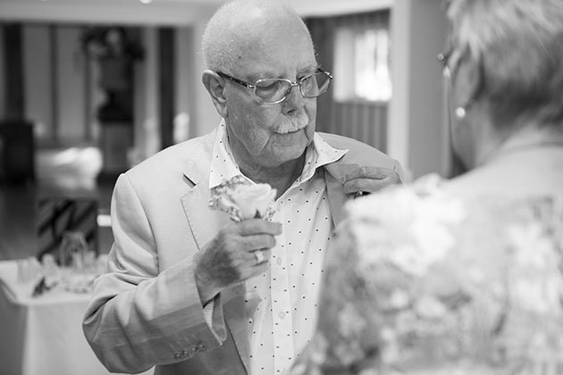 Wedding guest attaching buttonhole