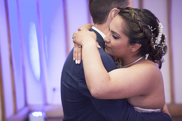 Bride with her arms around groom during their first dance at Vaulty Manor