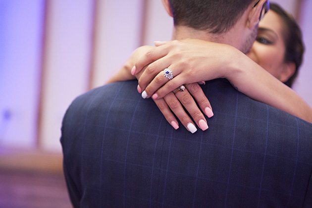 Close-up of bride's hands around groom during their first dance