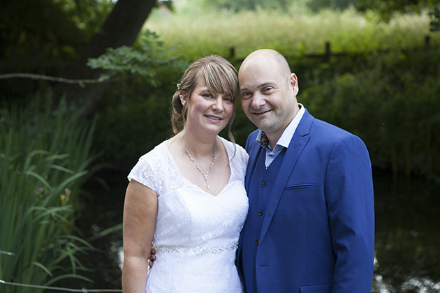 Natural portrait of bride and groom with a pond in the background
