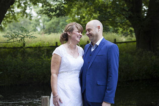 Natural portrait of bride and groom with a pond in the background