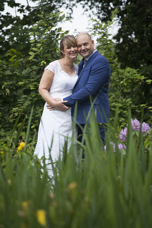 Natural portrait of bride and groom standing in tall grass