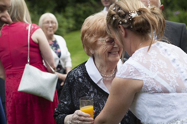 Candid image of bride and older friend with their heads together