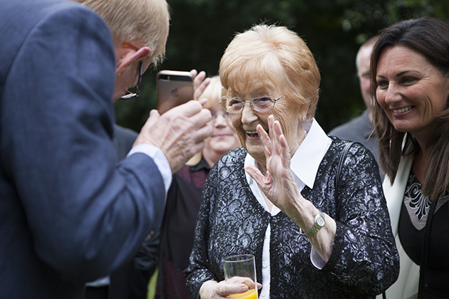 Wedding guest video conferencing on mobile phone and waving