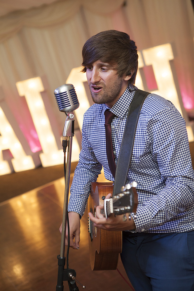 Man singing and playing acoustic guitar at a wedding