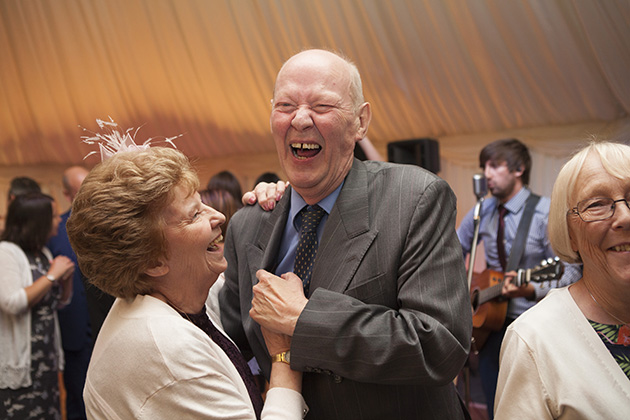 couple dancing during a party with guitar player in the background