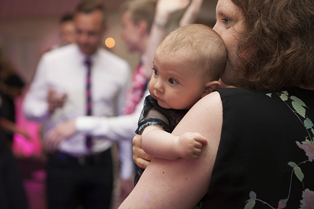 Close-up of baby being held my mother at a wedding party