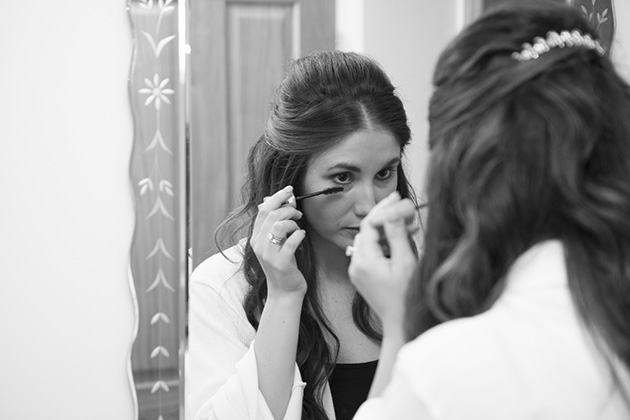 Bridesmaid looking in the mirror applying eye make-up