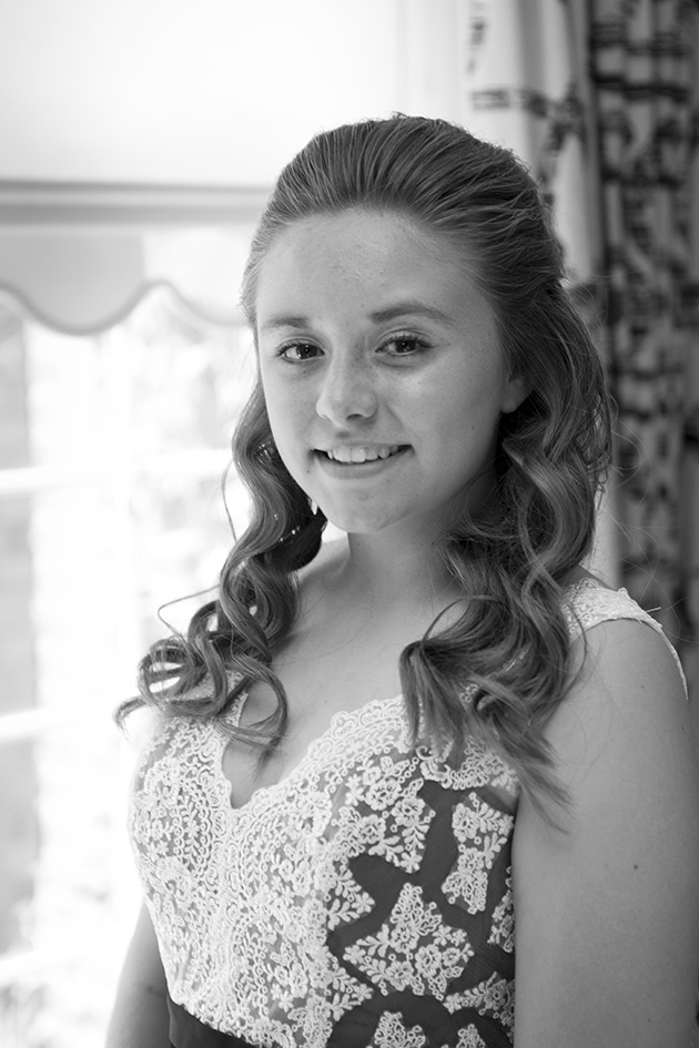 Portrait of teenage bridesmaid by a window