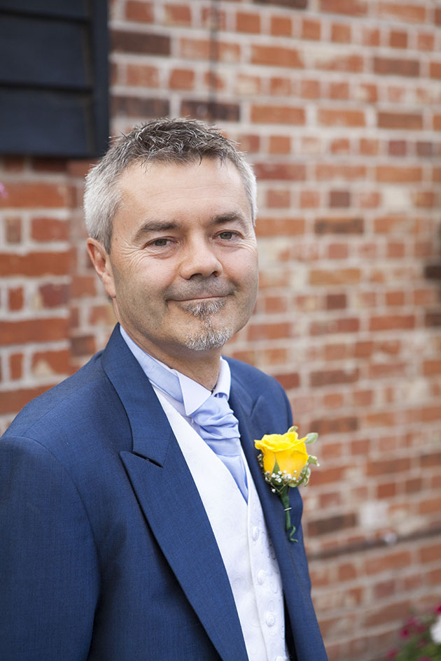 Portrait of best man against a brick wall