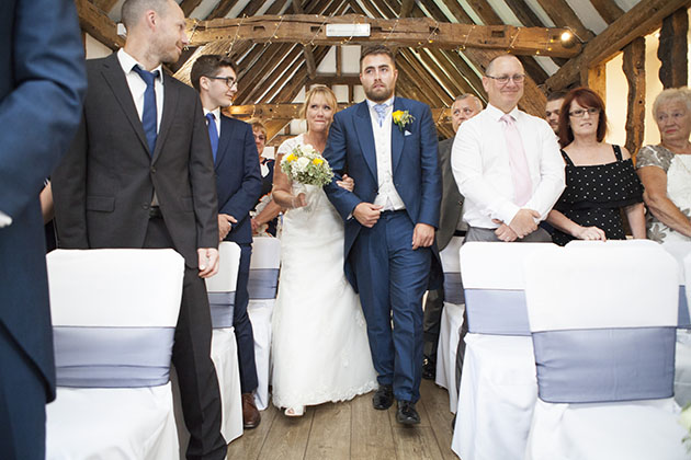 Bride walking down aisle with her son to meet groom