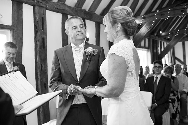 Groom putting a ring on the bride's finger during wedding ceremony