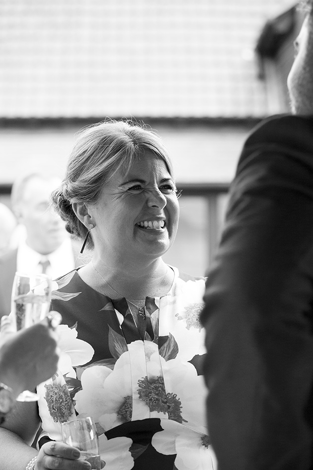Black and white photo of wedding guest laughing
