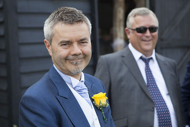 Natural portrait of wedding guest against painted black wooden barn