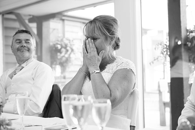 Emotional bride at top table during wedding speeches