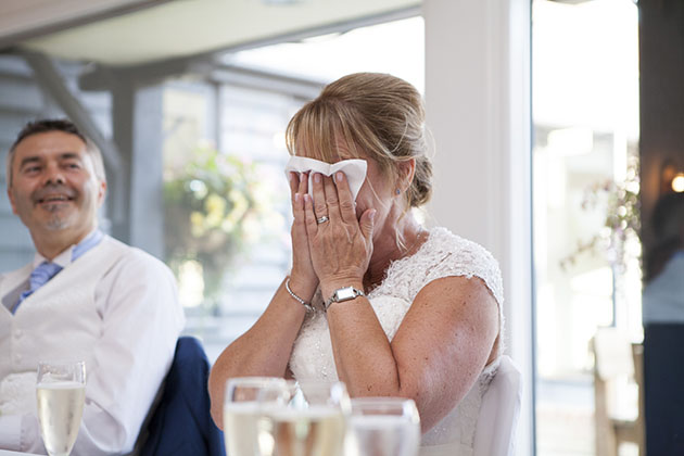 Emotional bride at top table during wedding speeches