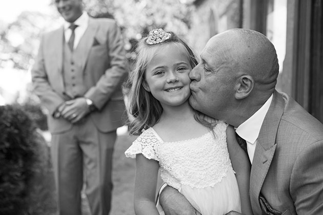 Groom kissing child bridesmaid