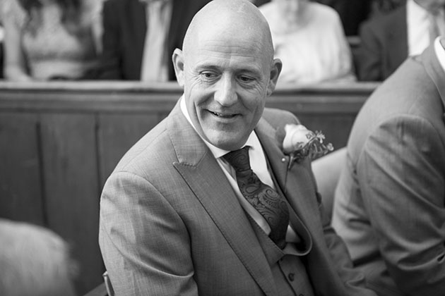 Candid photo of groom in church waiting for the bride