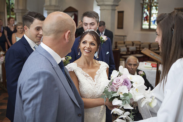 Bride's arrival in church meeting the groom and smiling