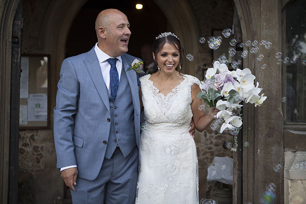 Bride and groom just coming out of church and standing in church doorway