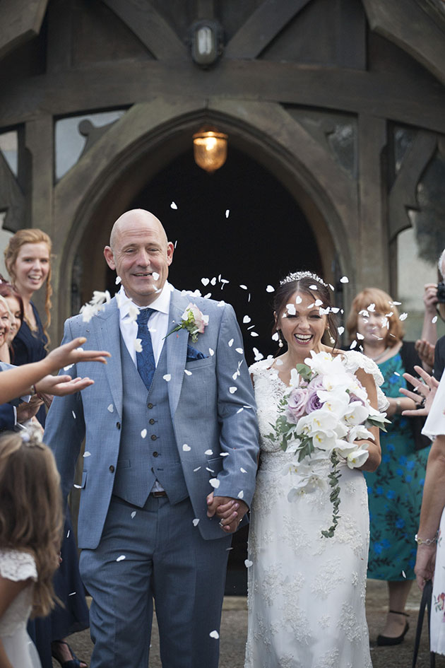 Married couple walking between rows of confetti throwers