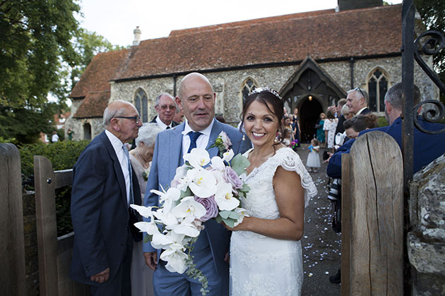 Married couple at end of church path just after the confetti throwing