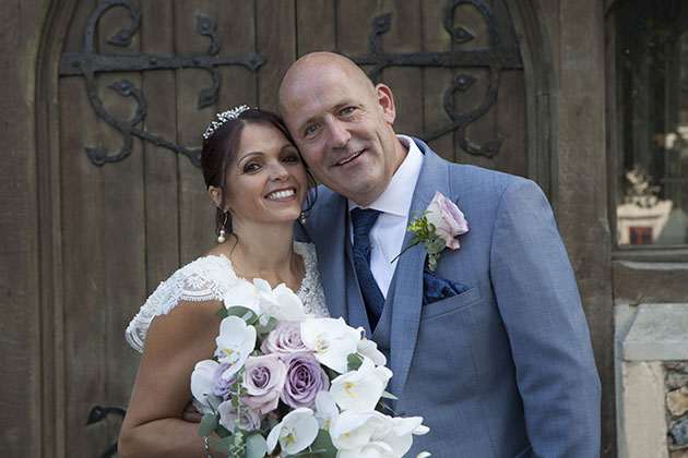 Bride and groom with heads together and looking at camera