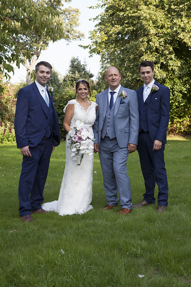 Formal wedding group photo in church garden