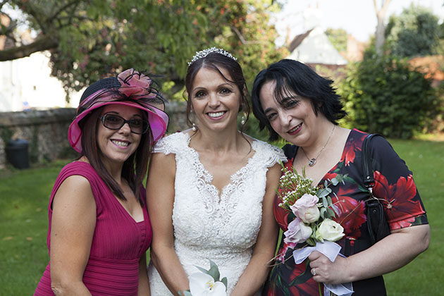 Bride with two friends looking camera