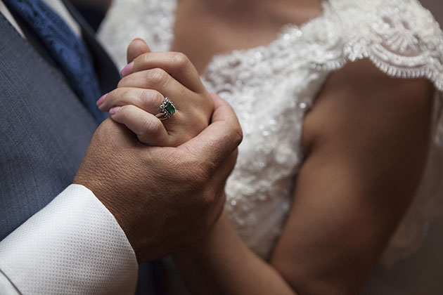 Close-up of bride and groom holding hands