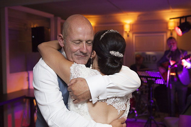 Groom with eyes closed hugging bride during first dance
