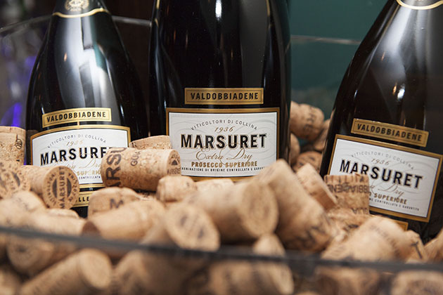 Three champagne bottles sitting in a bowl full of corks