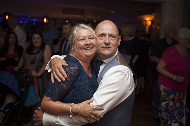 Man and woman hugging each other and looking at camera