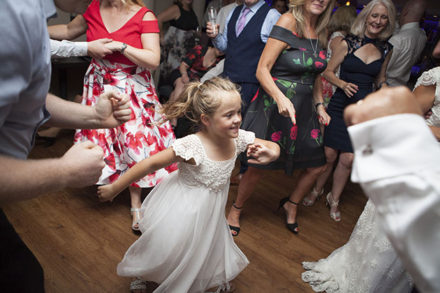 Young child dancing surrounded by wedding guests