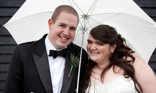 Bride and groom under an umbrella